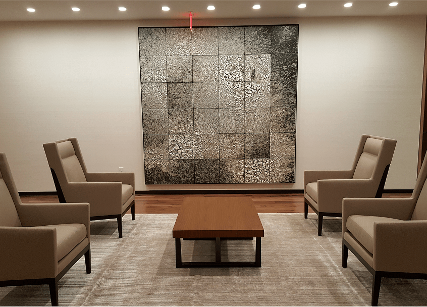 A room featuring several chairs arranged around a central table, creating a cozy seating area.