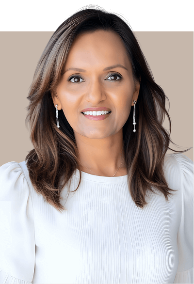 A woman wearing a white shirt and earrings, smiling softly against a neutral background.