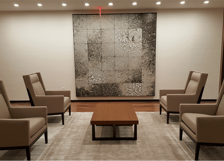 A room featuring several chairs arranged around a central table, creating a cozy seating area.