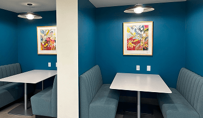 A blue room featuring two tables and chairs arranged for seating.