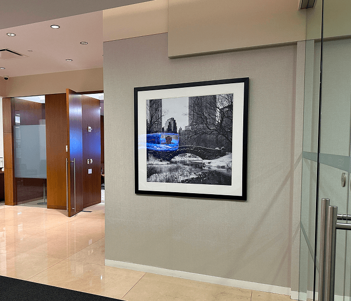 An office displays a framed photograph showcasing a vibrant city skyline against a clear sky.