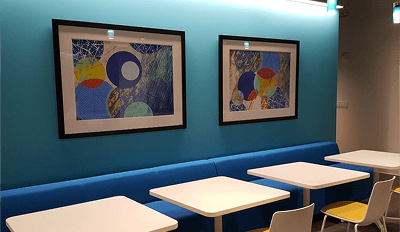 A blue wall featuring two framed paintings, adding color and art to the space.
